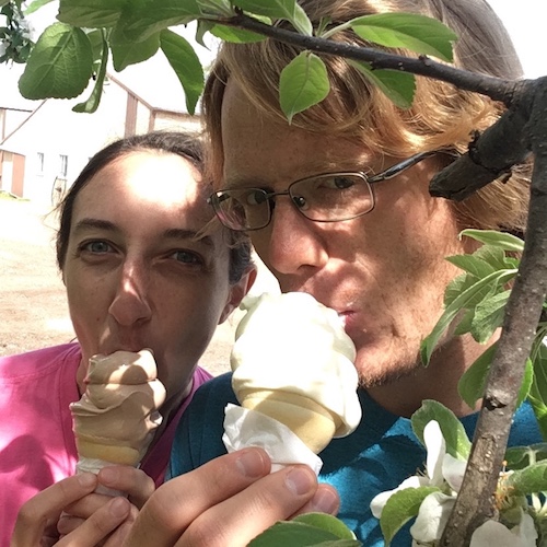 Photo of Elaine and Ben eating ice cream under the apple blossoms